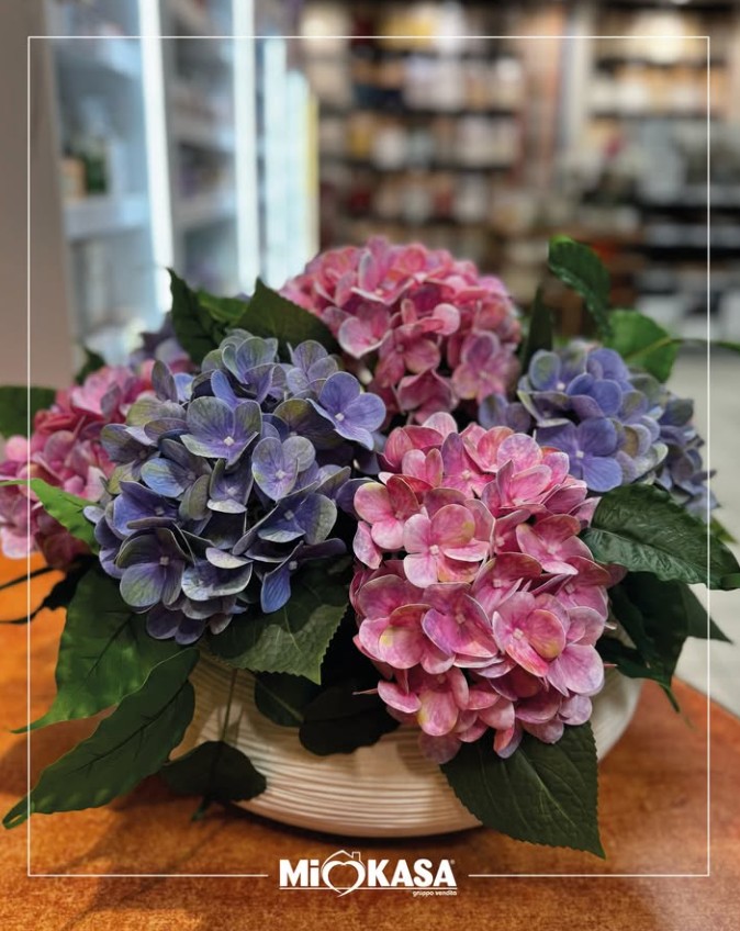 Composizione di ortensie viola e rosa in vaso bianco